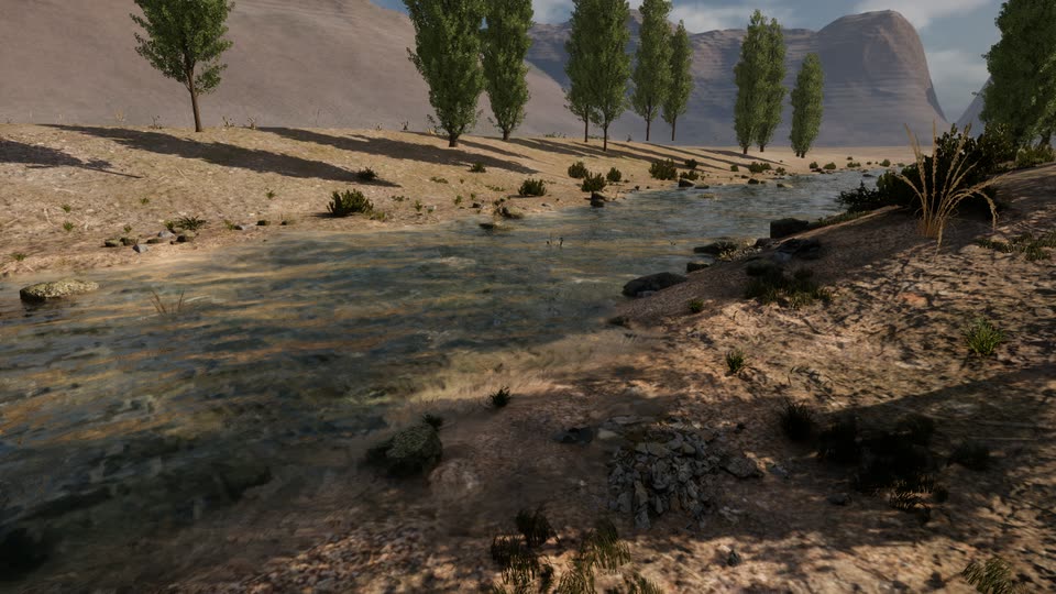Clear river water over a gravel bed beside a sandy bank with dry grass, a row of poplars and a pale limestone peak in the distance.